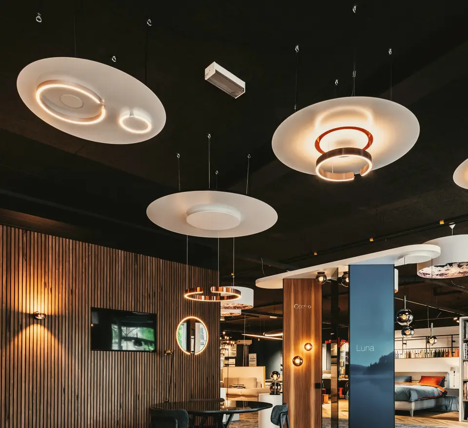 Lichtschijven met koperen ringen boven de adviestafel in onze showroom